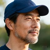 一位约35岁的成熟男性玩家头像，戴着深蓝色棒球帽，胡须修剪整齐，背景为户外自然光线